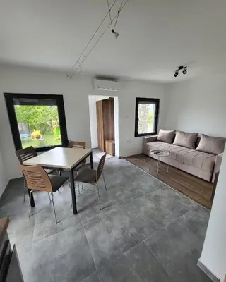 a living room with a table and a couch at Duos East in Soko Banja