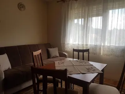 a living room with a table and chairs and a couch at Vila Happy Story in Knjazevac.