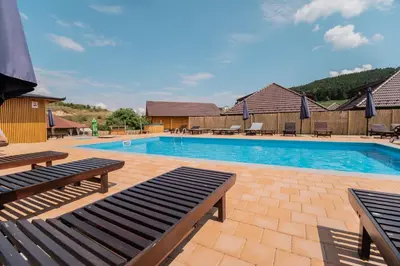 a swimming pool with two benches in front of it at Kedar selo Goč in Goč
