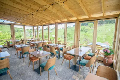 a restaurant with tables and chairs and windows at Kedar selo Goč in Goč