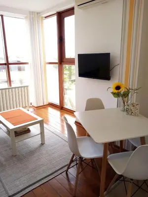 a living room with a table and a tv on the wall at Raj Pegaz in Vrnjačka Banja