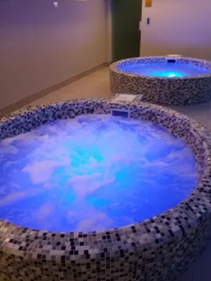 a hot tub with blue water and clouds in it at Raj Pegaz in Vrnjačka Banja