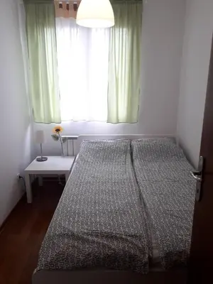 a bedroom with a large bed with a window at Raj Pegaz in Vrnjačka Banja