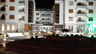 a building with a fountain in front of it at night at Raj Pegaz in Vrnjačka Banja