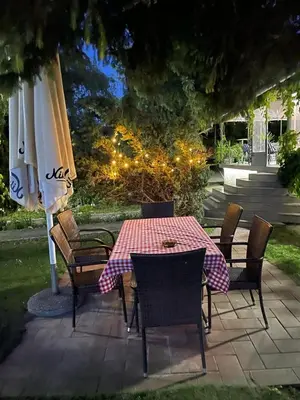 a table with chairs and an umbrella on a patio at Veliki Raj Plus in Stenjevac
