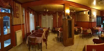 a restaurant with tables and chairs in a room at Veliki Raj Plus in Stenjevac