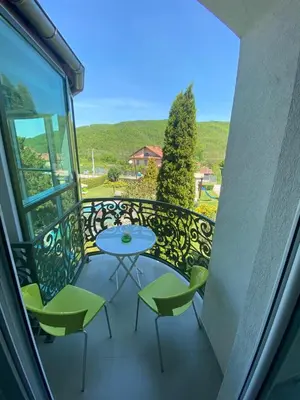 a balcony with a table and chairs and a view at Veliki Raj Plus in Stenjevac