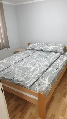 a bed in a room with at Comfort Inn Apartmani in Vrnjačka Banja