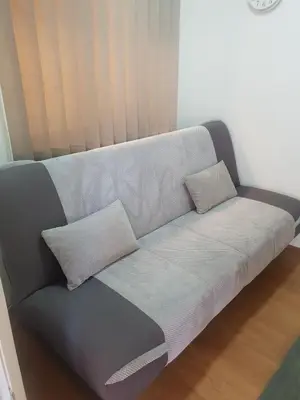 a couch with two pillows on it in a room at Comfort Inn Apartmani in Vrnjačka Banja