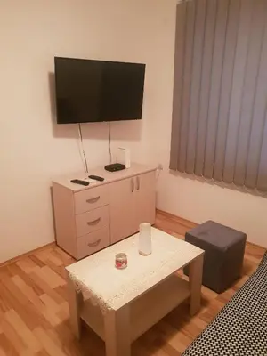 a living room with a tv and a coffee table at Comfort Inn Apartmani in Vrnjačka Banja