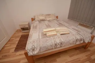 a bedroom with a bed with a wooden floor at Comfort Inn Apartmani in Vrnjačka Banja