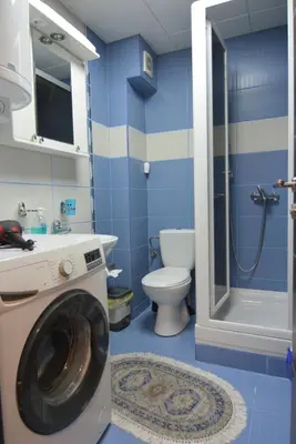 a blue bathroom with a washing machine in it at Apartman NEDA - 5 minuta od centra in Vrnjačka Banja