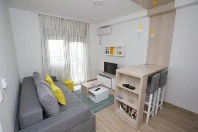 a living room with a gray couch and a television at Fast Sleep & Go 3 in Paraćin