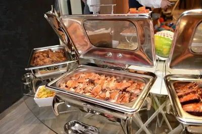 a buffet with several trays of food on a table at Hotel Royal Putnik in Vranje