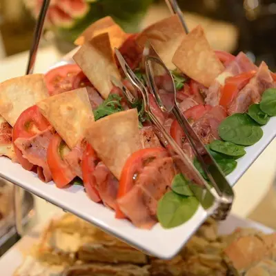 a plate of food with sandwiches and tomatoes at Hotel Royal Putnik in Vranje