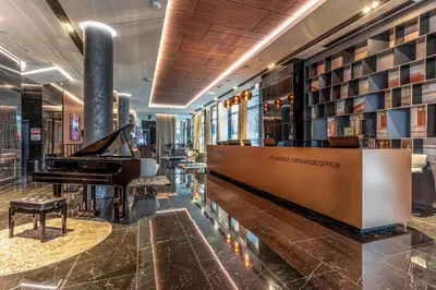 a hotel lobby with a piano and a library at Hotel Royal Putnik in Vranje