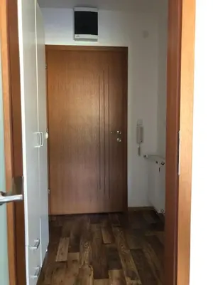 a hallway with a wooden door with a television on top at Studio Apartman NENA in Vrnjačka Banja