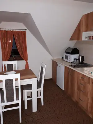 a kitchen with a table and chairs and a kitchen with a counter at Apartmani Pavlović in Kopaonik