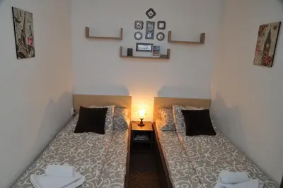 a room with two beds and a light on the wall at Apartmani Pavlović in Kopaonik
