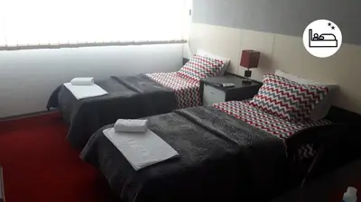 a hotel room with two beds and two chairs at Rooms S&S Milicevic u strogom centru Aleksandrovca in Aleksandrovac