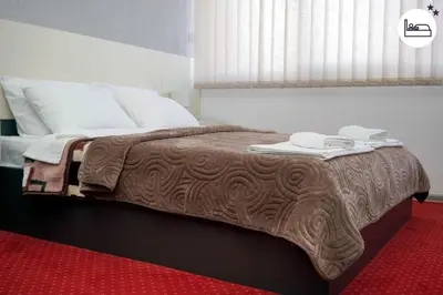a bed with a brown blanket and towels on it at Rooms S&S Milicevic u strogom centru Aleksandrovca in Aleksandrovac
