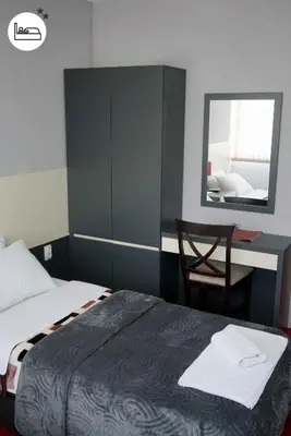 a bedroom with a bed and a mirror and a chair at Rooms S&S Milicevic u strogom centru Aleksandrovca in Aleksandrovac