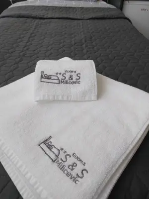 a close up of a bed with towels on it at Rooms S&S Milicevic u strogom centru Aleksandrovca in Aleksandrovac