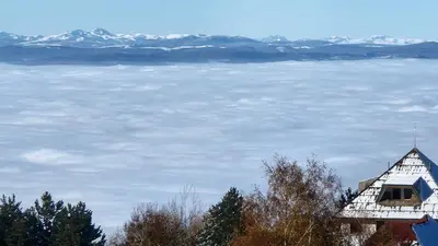 a view of the snow covered mountains from a house at KOP P95 Milmari in Kopaonik