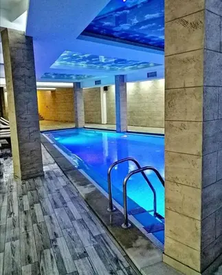 a large swimming pool with blue lighting in a building at KOP P95 Milmari in Kopaonik