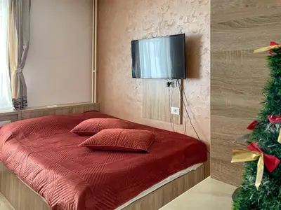a bedroom with a red bed with a television on the wall at Kopaonik Centar Konaci in Kopaonik