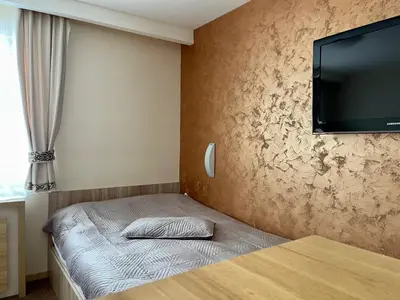a bedroom with a bed with a flat screen tv on the wall at Kopaonik Centar Konaci in Kopaonik