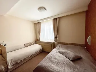 a small room with two beds and a window at Kopaonik Centar Konaci in Kopaonik