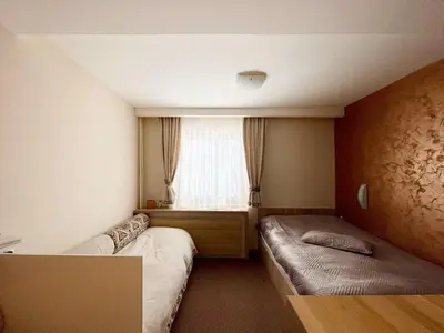 a small room with two beds and a window at Kopaonik Centar Konaci in Kopaonik