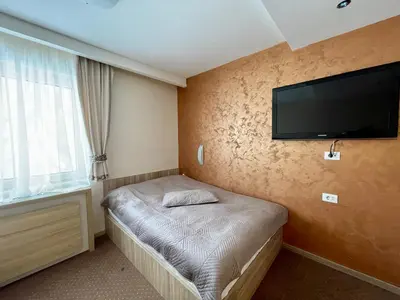 a bedroom with a bed with a flat screen tv on the wall at Kopaonik Centar Konaci in Kopaonik