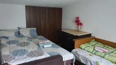 a bedroom with a bed and a dresser with a vase of flowers at Apartmani Odmor i Mir in Vranje