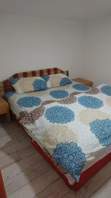 a bed with a quilt on it in a room at Apartmani Odmor i Mir in Vranje