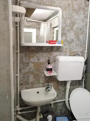 a bathroom with a sink and a toilet and a mirror at Apartmani Odmor i Mir in Vranje
