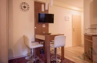 a room with a desk and two chairs and a tv at Villa Zvončica, Apartman ViN in Kopaonik