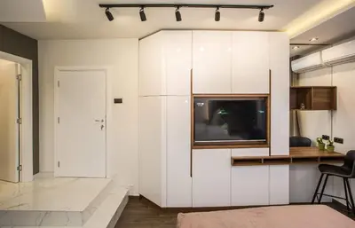 a living room with white cabinets and a tv at SACHER APARTMENTS in Niš