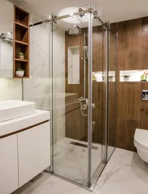 a bathroom with a glass shower and a toilet at SACHER APARTMENTS in Niš