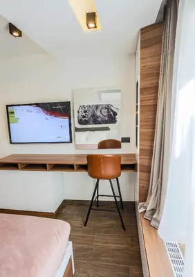 a bedroom with a desk with a computer and a chair at SACHER APARTMENTS in Niš