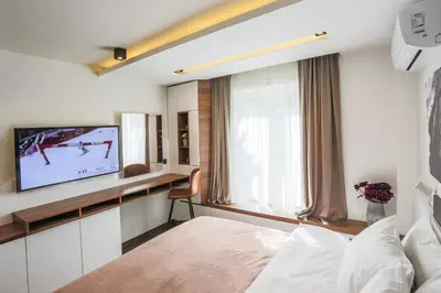a hotel room with a tv and a bed at SACHER APARTMENTS in Niš
