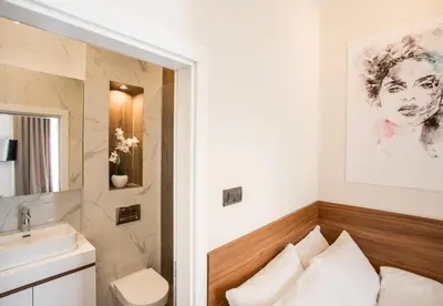 a bathroom with a toilet and a sink at SACHER APARTMENTS in Niš