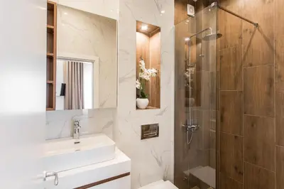 a bathroom with a shower and a sink and a toilet at SACHER APARTMENTS in Niš