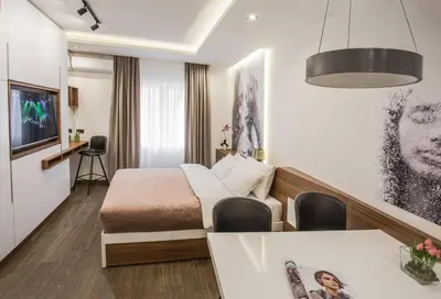 a hotel room with a bed and a dining table at SACHER APARTMENTS in Niš