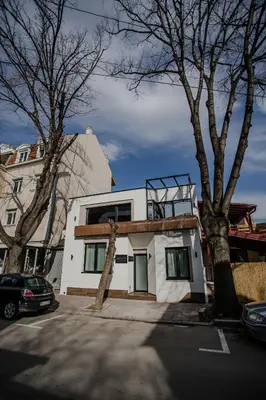 a white house with windows on top of it at SACHER APARTMENTS in Niš
