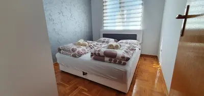 a bedroom with a bed with pillows and a window at KIKI LUX Apartment in Vrnjačka Banja