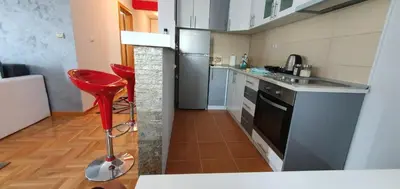 a kitchen with a red stool in a small kitchen at KIKI LUX Apartment in Vrnjačka Banja