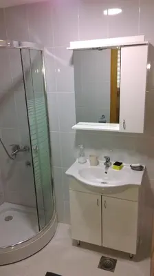 a bathroom with a sink and a shower and a mirror at KIKI LUX Apartment in Vrnjačka Banja