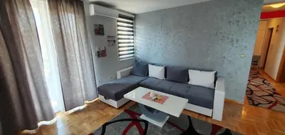 a living room with a blue couch and a table at KIKI LUX Apartment in Vrnjačka Banja